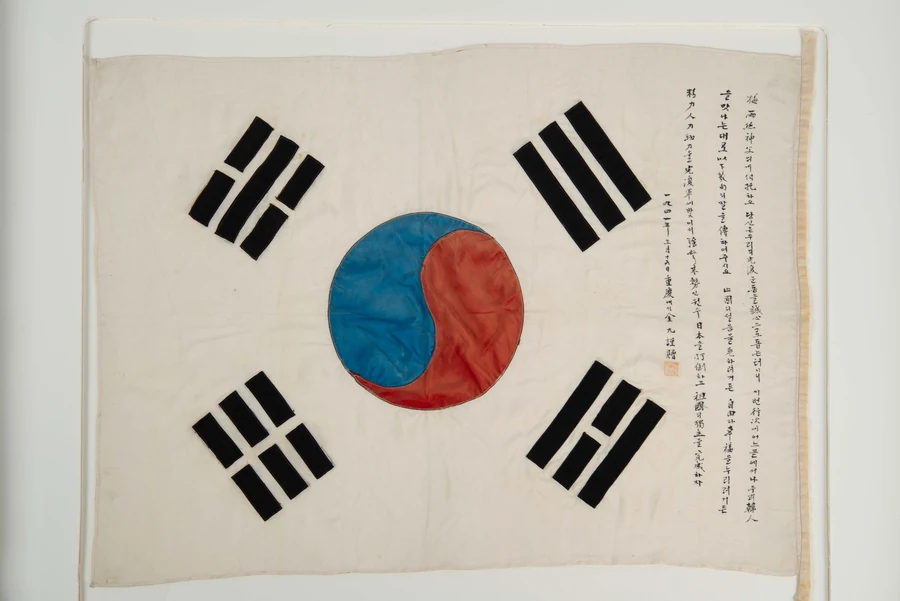 김구 서명문 태극기 실물 — 오른쪽 여백에 광복군 지원을 호소하는 친필이 세로로 적혀 있다